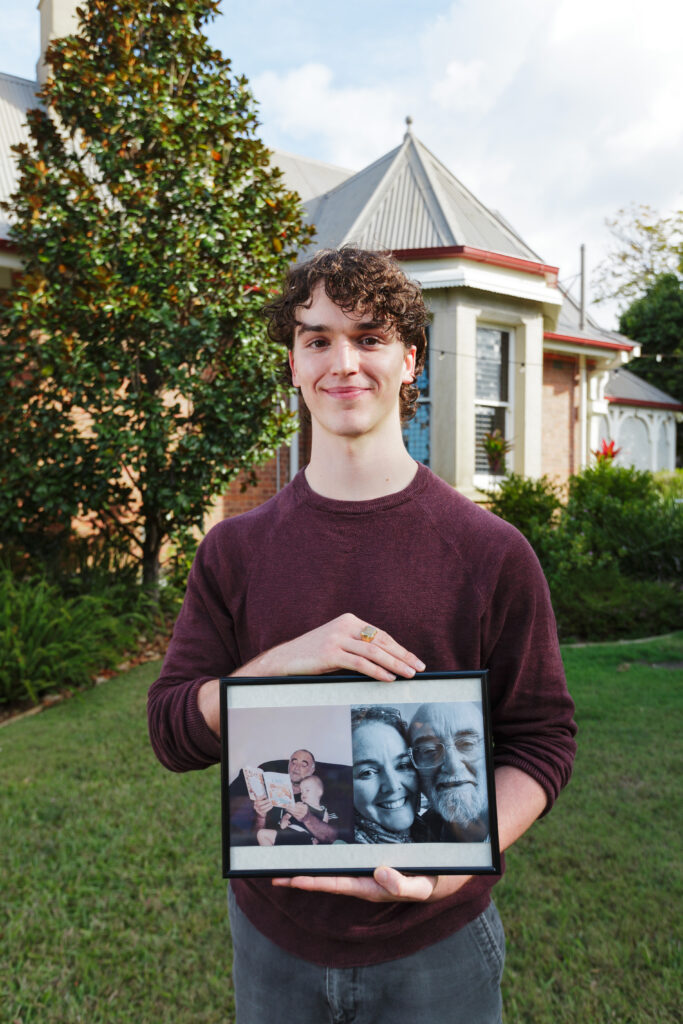 Photo of Angus Ruggieri-Guthrie holding a photograph of his loved ones